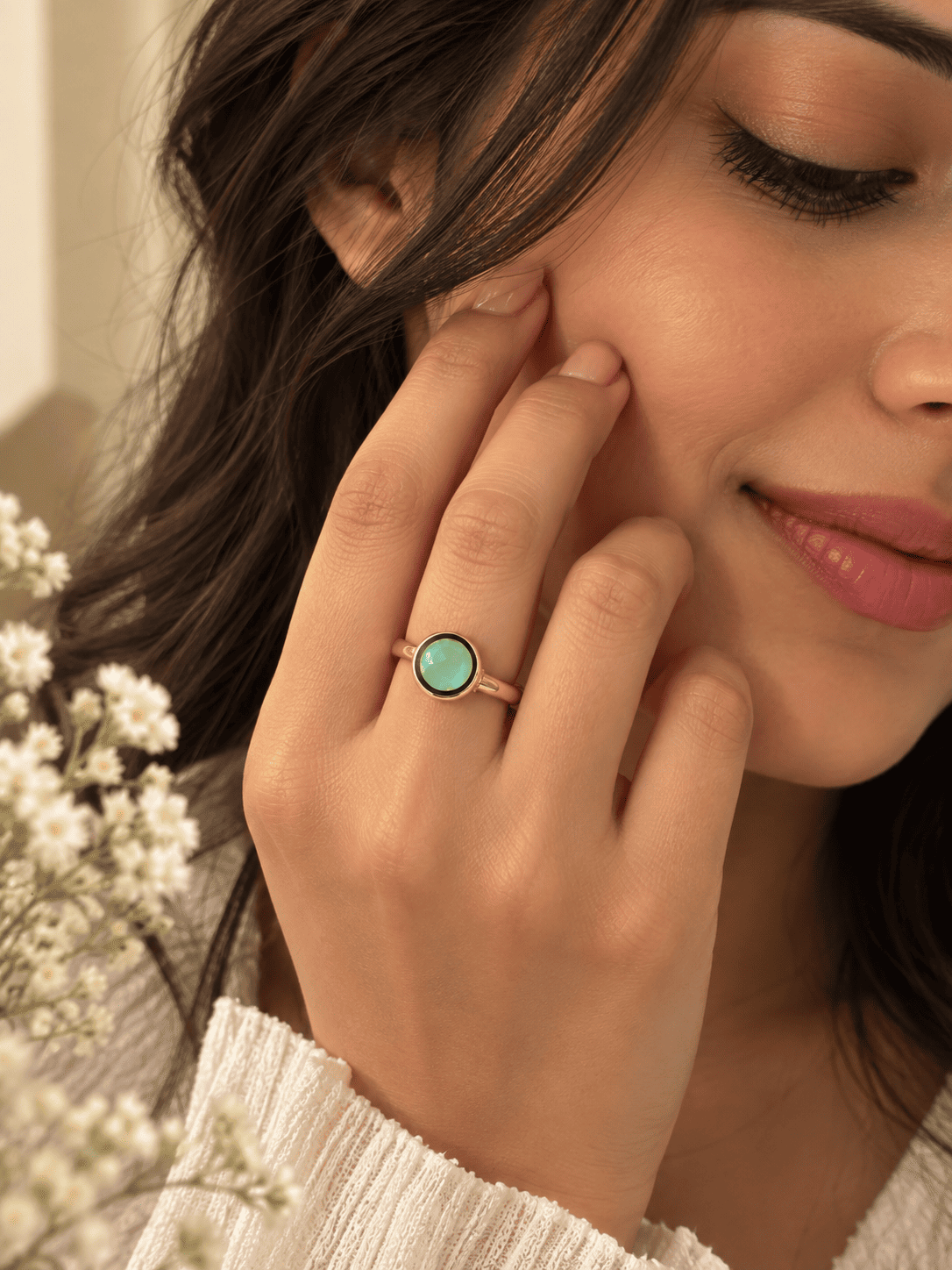 A soft mint green stone paired with elegant gold-tone detailing.