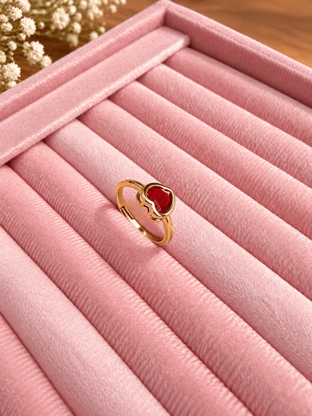 Red Heart Stone Ring for Women – Gold Tone 3 Red heart stone ring on pink jewellery tray